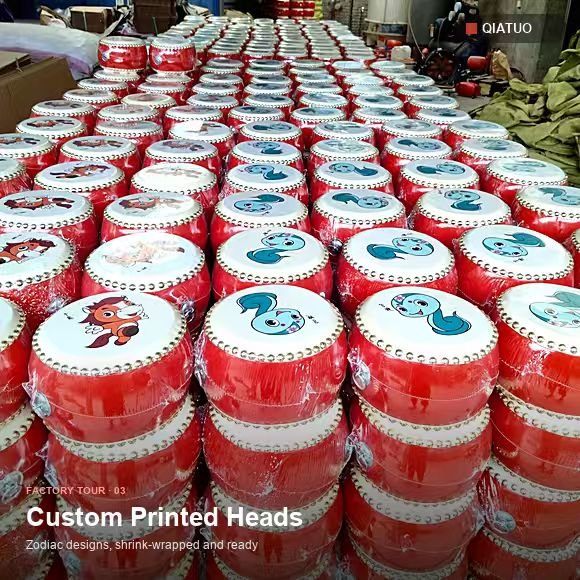 Rows of finished QiaTuo red drums with custom printed heads on the workshop floor in Matun Village