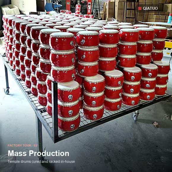 Racks of finished red temple drums stacked in the QiaTuo production workshop