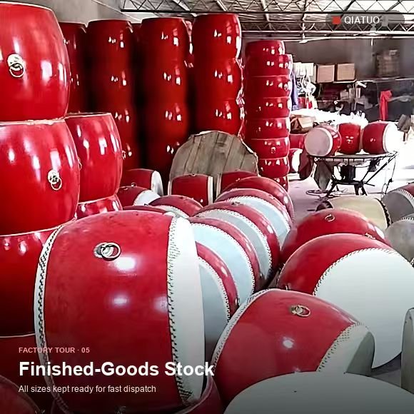 Finished red drums with white heads stacked in the QiaTuo workshop