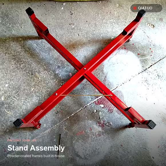 Two red powder-coated metal drum stands on the workshop floor